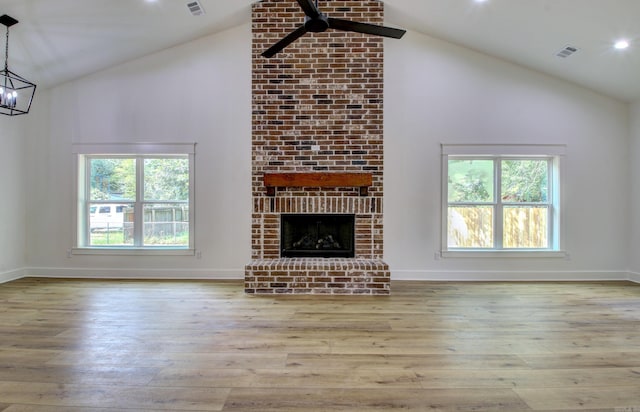 unfurnished living room with a fireplace, light hardwood / wood-style floors, and high vaulted ceiling