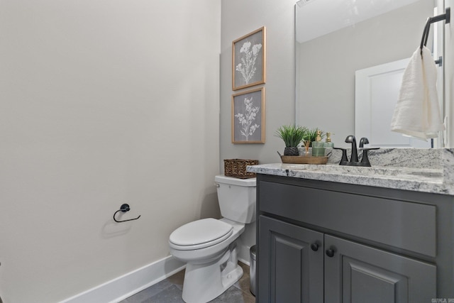 bathroom featuring tile patterned flooring, vanity, and toilet