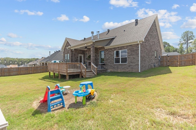 back of property featuring a deck and a lawn