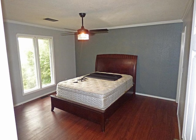 bedroom featuring multiple windows, ornamental molding, ceiling fan, and dark wood-type flooring