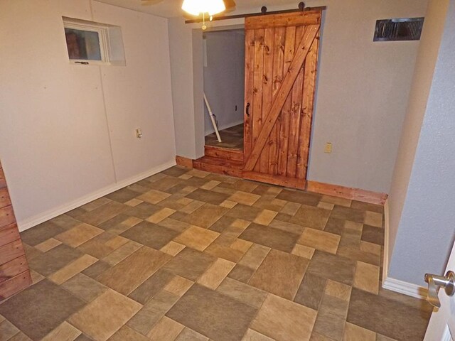 empty room with ceiling fan and a barn door