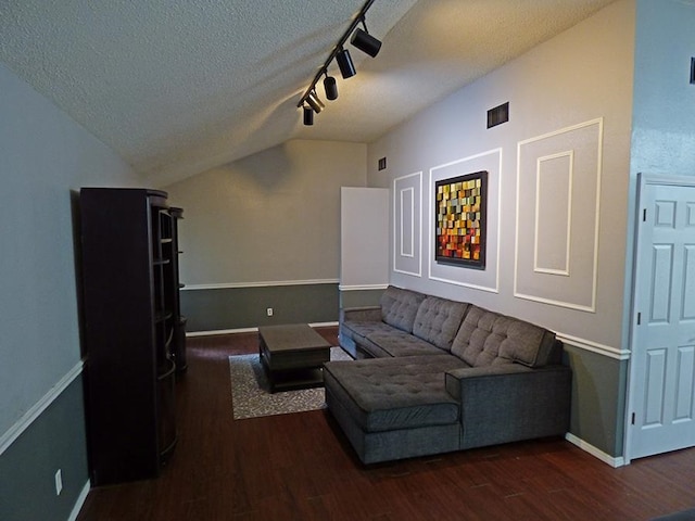 living room featuring vaulted ceiling, a textured ceiling, track lighting, and dark hardwood / wood-style floors