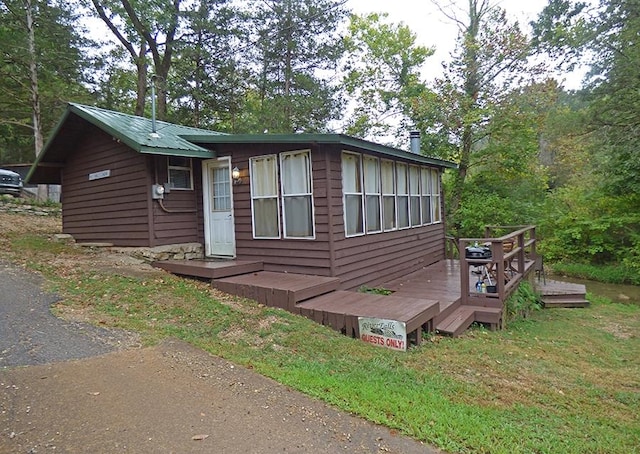 view of front facade featuring a front lawn and a wooden deck