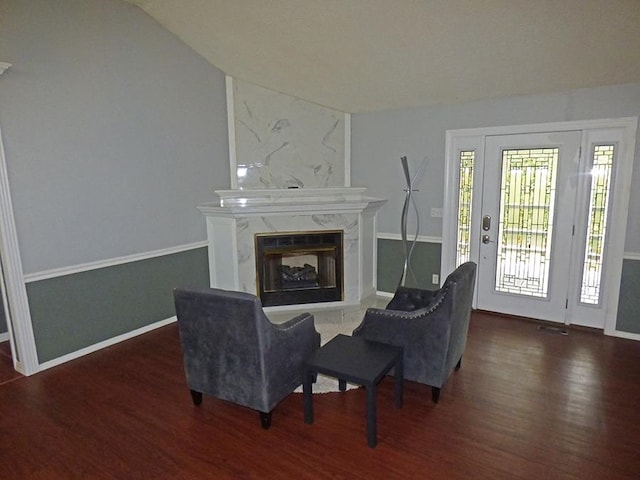 living room featuring lofted ceiling, a high end fireplace, and dark hardwood / wood-style flooring