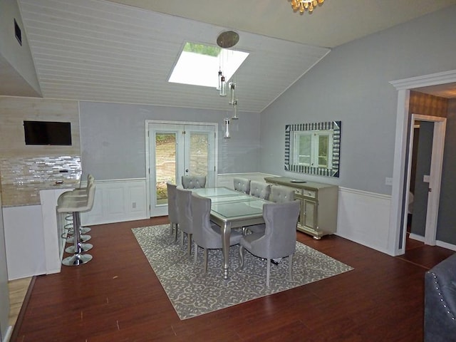 dining room with dark wood-type flooring and lofted ceiling with skylight