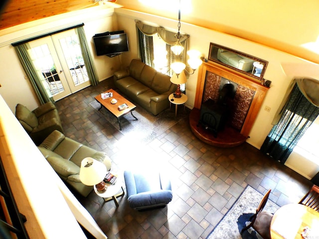 living room with french doors, a wood stove, and a healthy amount of sunlight