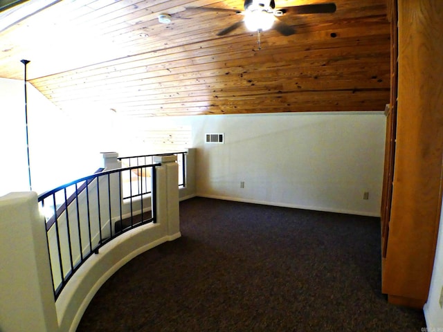 corridor featuring dark colored carpet, vaulted ceiling, and wooden ceiling