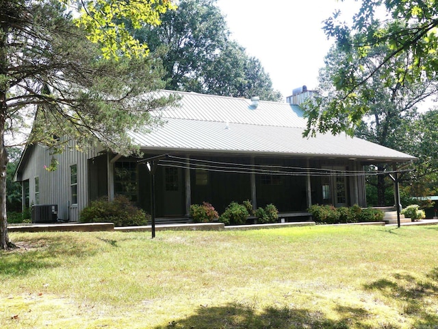 back of house with cooling unit and a yard