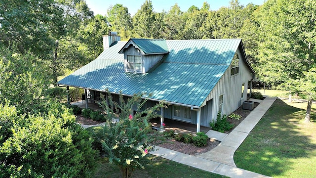 view of front of property featuring cooling unit, a front lawn, and a porch