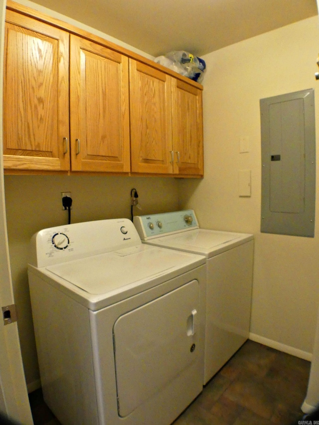 clothes washing area with electric panel, washer and dryer, and cabinets