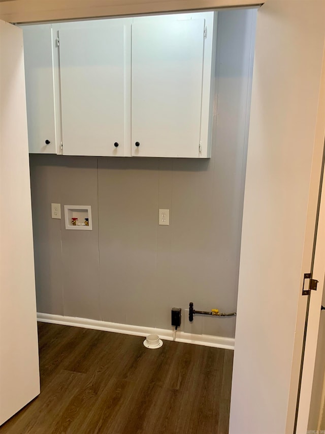 clothes washing area with cabinets, washer hookup, and dark wood-type flooring