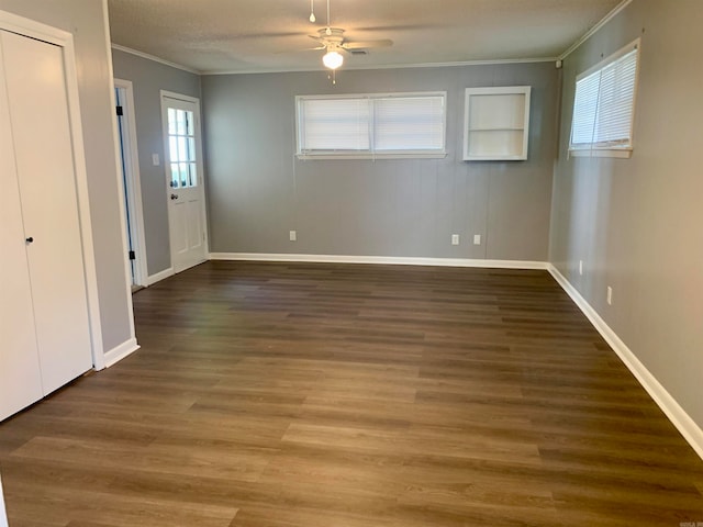 interior space with ornamental molding, ceiling fan, and dark hardwood / wood-style flooring