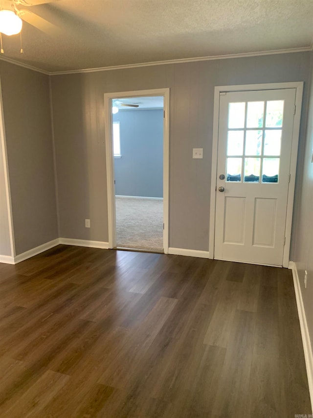 entryway with a textured ceiling, ornamental molding, dark wood-type flooring, and ceiling fan