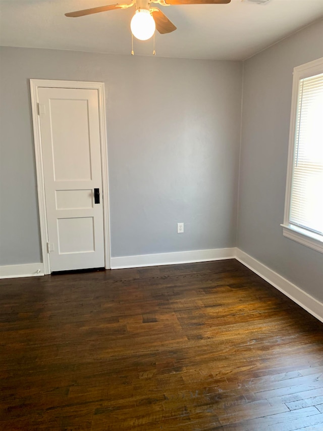 spare room with ceiling fan and dark wood-type flooring