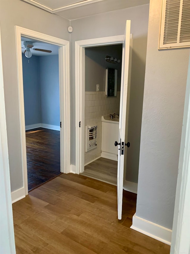 corridor featuring heating unit and hardwood / wood-style floors