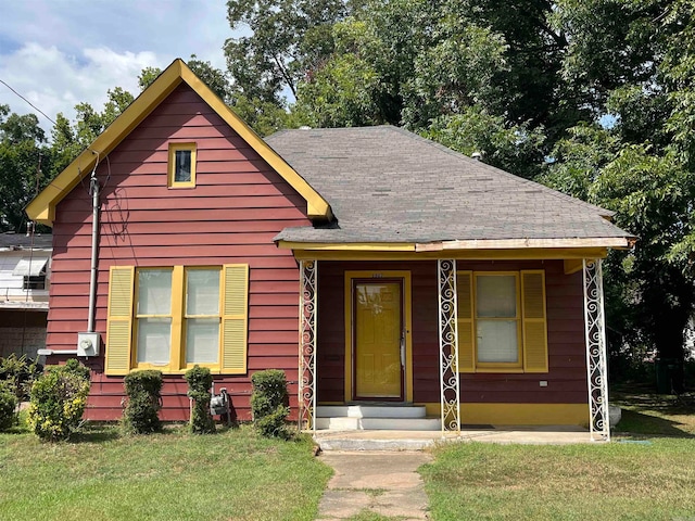 view of front of house with a front yard and covered porch