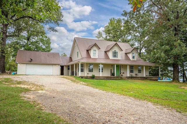 farmhouse with covered porch, a front yard, and a garage