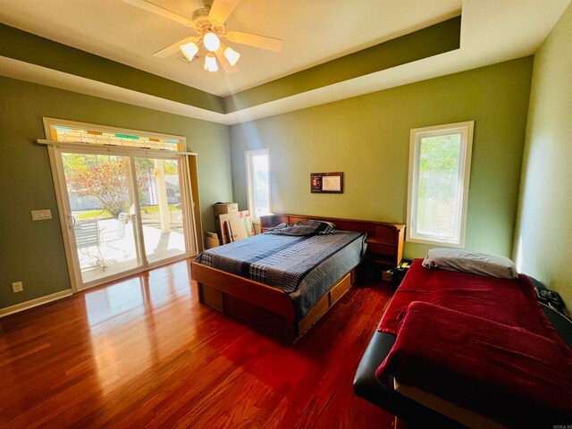 bedroom with multiple windows, access to outside, dark hardwood / wood-style floors, and ceiling fan