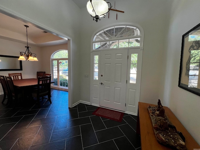 tiled entryway with a chandelier