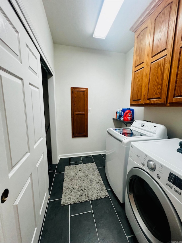 laundry area with cabinets, dark tile patterned flooring, and independent washer and dryer