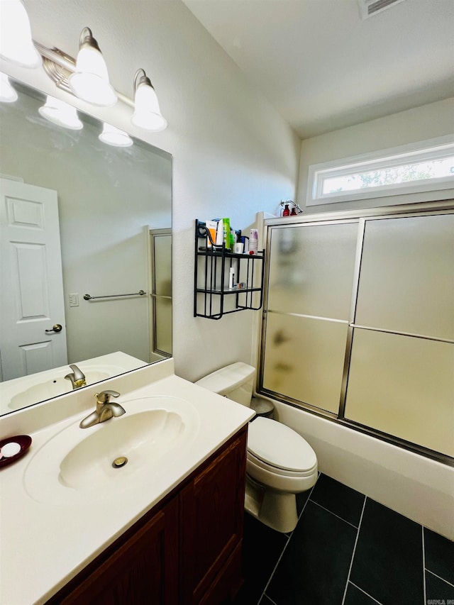 full bathroom with enclosed tub / shower combo, vanity, tile patterned flooring, and toilet