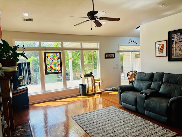 living room featuring hardwood / wood-style floors and ceiling fan