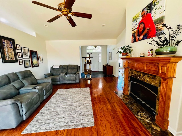 living room featuring ceiling fan and dark wood-type flooring