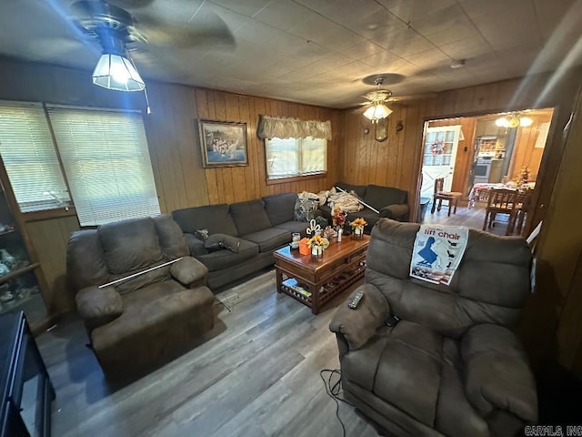 living room with wooden walls, ceiling fan, and hardwood / wood-style flooring