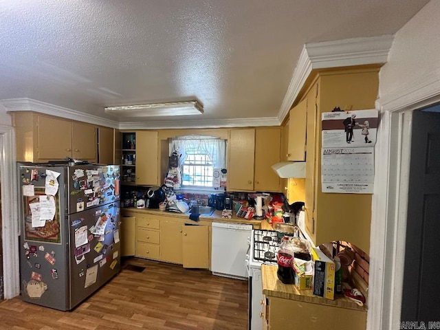 kitchen with a textured ceiling, hardwood / wood-style flooring, crown molding, and white appliances