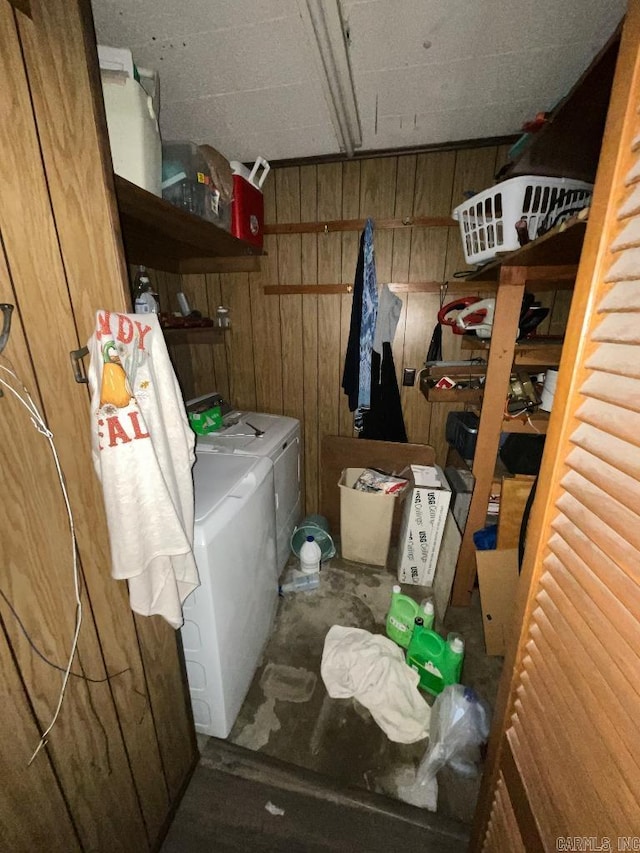 washroom featuring wooden walls and independent washer and dryer