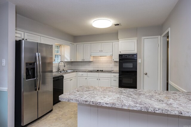 kitchen with light tile patterned flooring, tasteful backsplash, white cabinets, black appliances, and sink