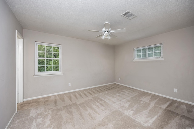 carpeted empty room with ceiling fan and a textured ceiling