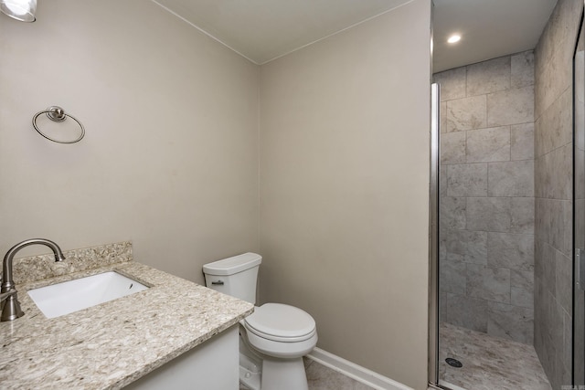 bathroom with vanity, toilet, and tiled shower