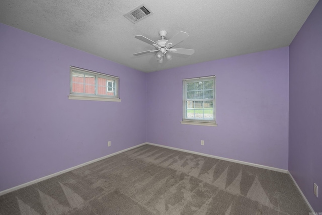 spare room with carpet, ceiling fan, and a textured ceiling