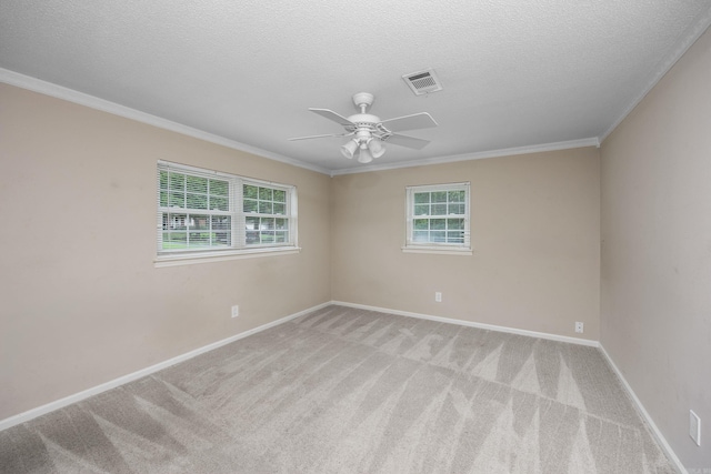 carpeted spare room featuring ceiling fan, a textured ceiling, and ornamental molding