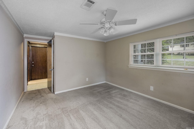 unfurnished room featuring ceiling fan, light colored carpet, a textured ceiling, and crown molding