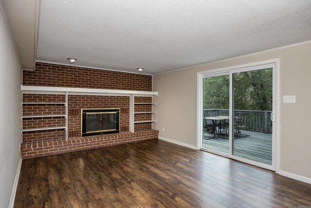 unfurnished living room featuring a brick fireplace, a textured ceiling, and dark hardwood / wood-style floors