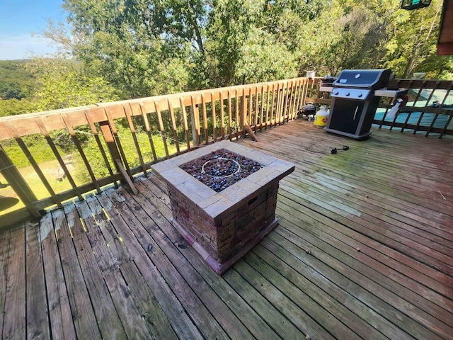 wooden deck with area for grilling and an outdoor fire pit