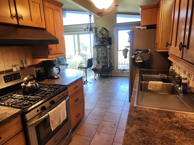 kitchen with a healthy amount of sunlight, gas range, vaulted ceiling, and sink