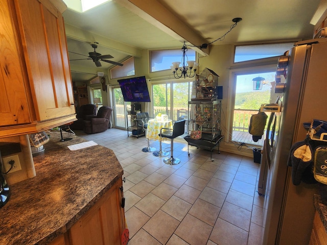 kitchen featuring refrigerator, ceiling fan with notable chandelier, lofted ceiling with beams, and light tile patterned floors