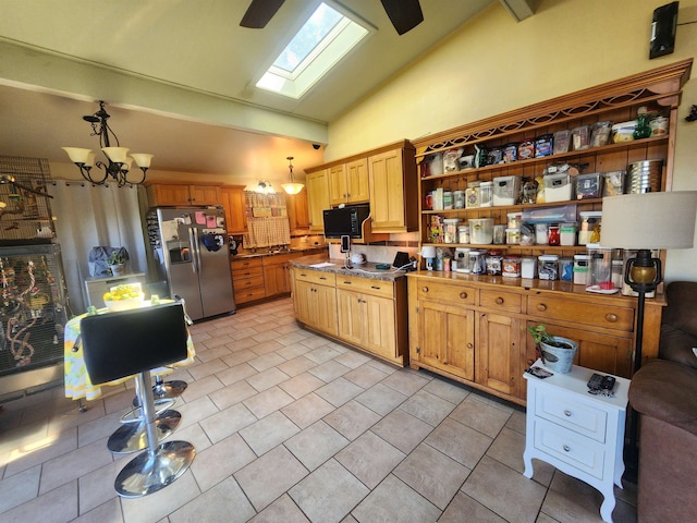 kitchen with stainless steel fridge, lofted ceiling with skylight, and pendant lighting