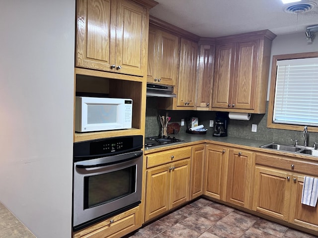 kitchen with sink, black gas cooktop, stainless steel oven, and tasteful backsplash