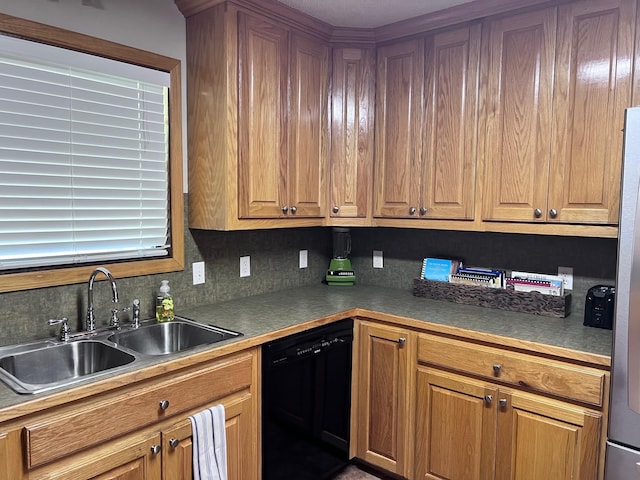 kitchen featuring black dishwasher, sink, and tasteful backsplash