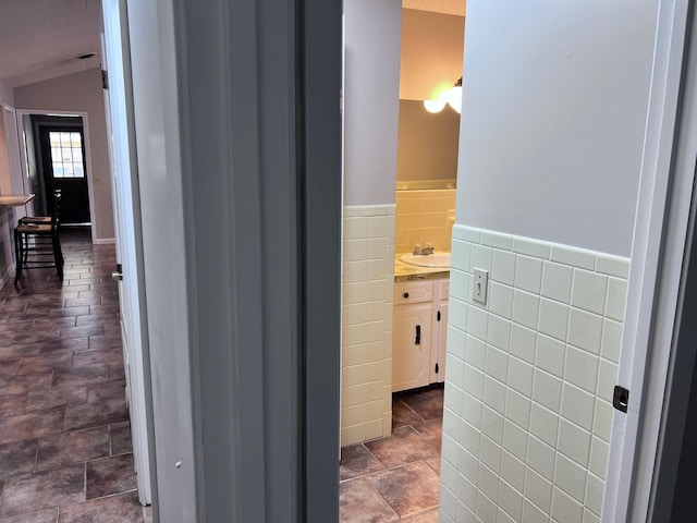 236 N Riverview Ln, Mountain View, AR 72560 - bathroom featuring tile walls, lofted ceiling, vanity, and wainscoting