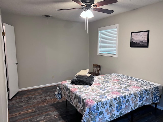 bedroom with ceiling fan, dark hardwood / wood-style floors, and a textured ceiling