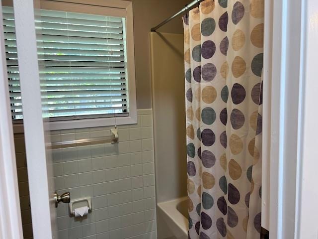 bathroom with shower / bath combination with curtain and tile walls