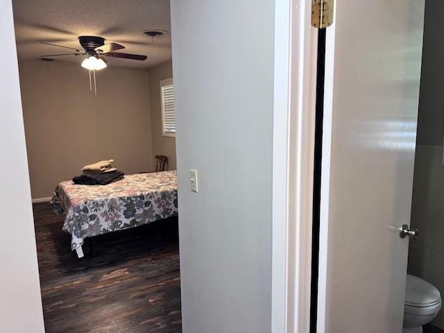 bedroom with ceiling fan, a textured ceiling, and wood-type flooring