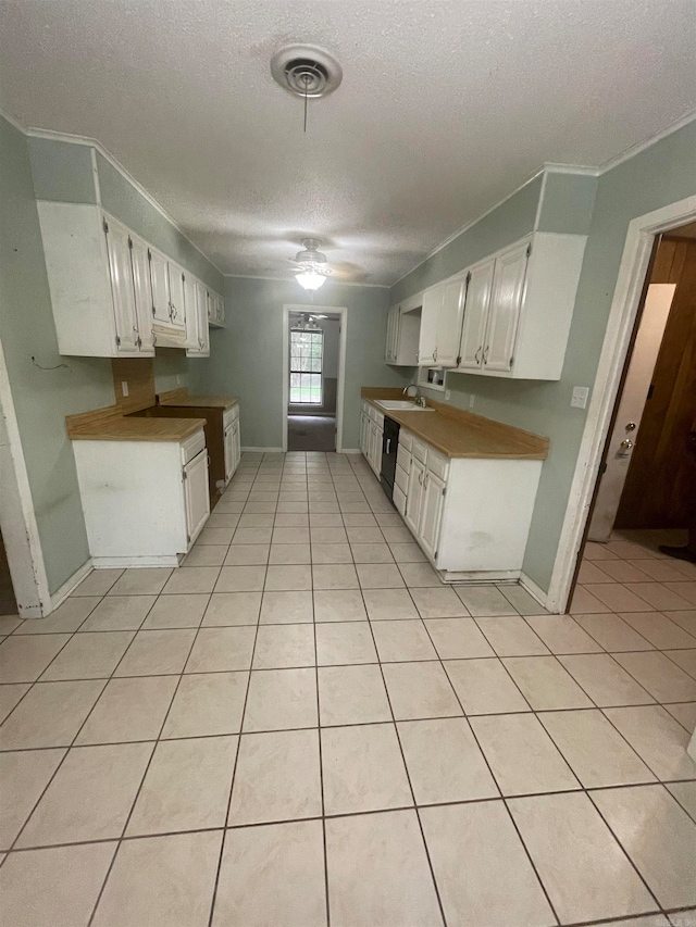 kitchen featuring white cabinets, light tile patterned floors, a textured ceiling, crown molding, and ceiling fan