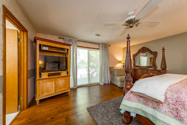 bedroom with ceiling fan, access to exterior, dark wood-type flooring, and a textured ceiling