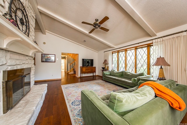 living room with ceiling fan, a fireplace, lofted ceiling with beams, and dark hardwood / wood-style flooring